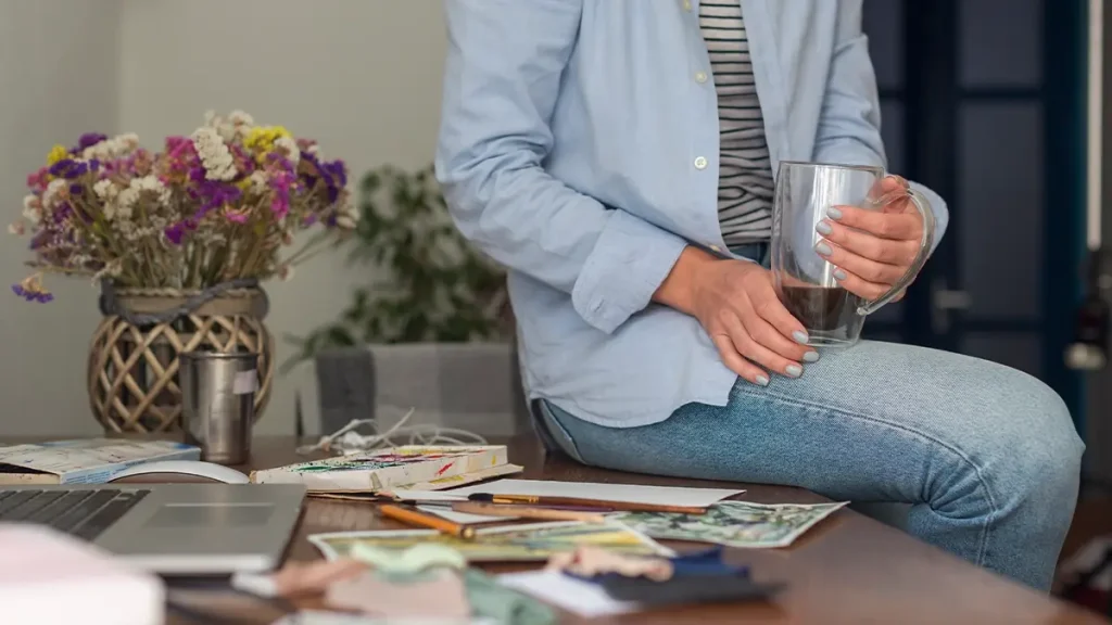 Persona sentada en un escritorio con una taza de café, disfrutando de la tranquilidad que ofrecen los préstamos para reunificar deudas.