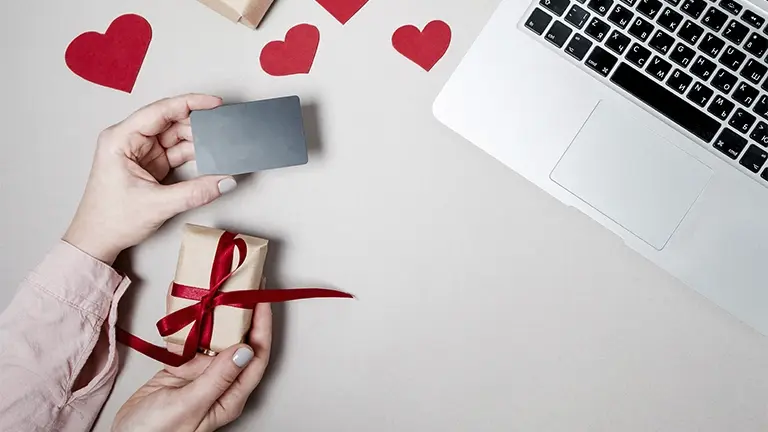 Persona realizando una compra online con tarjeta para regalos de San Valentín.